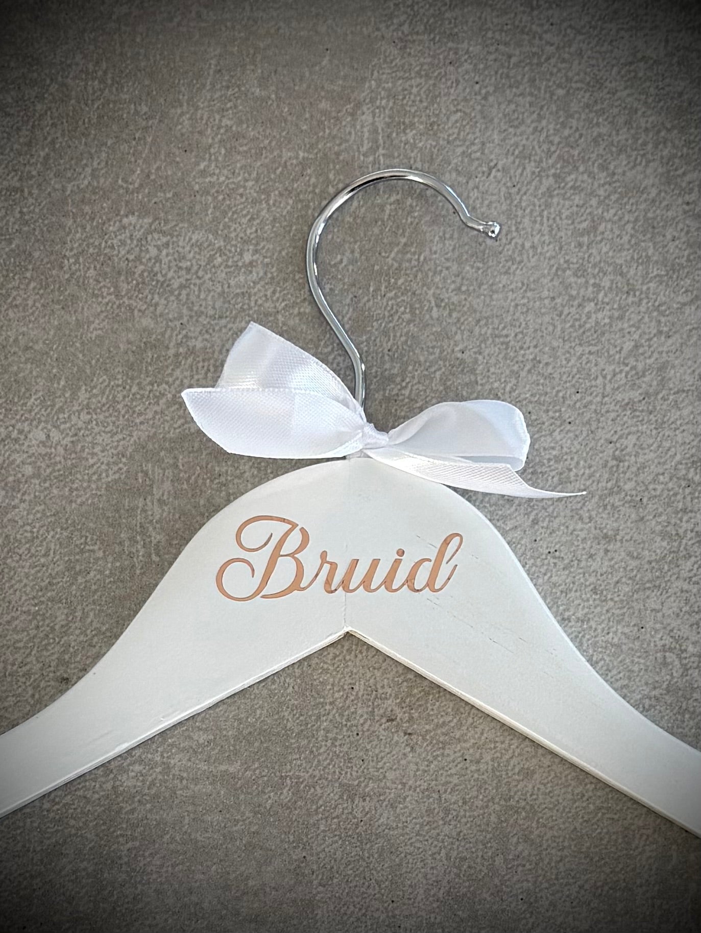 White wooden hanger with rose gold Bruid vinyl and a white ribbon bow
