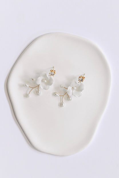 Gold bridal earring with single porcelain flower and fresh water pearls.