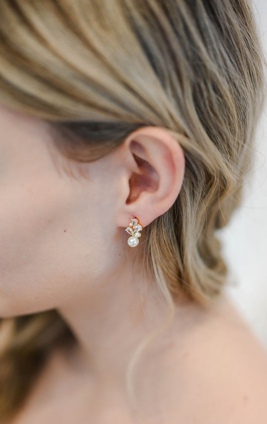 Bride wearing dainty gold stud earring with cubic zirconia and pearls